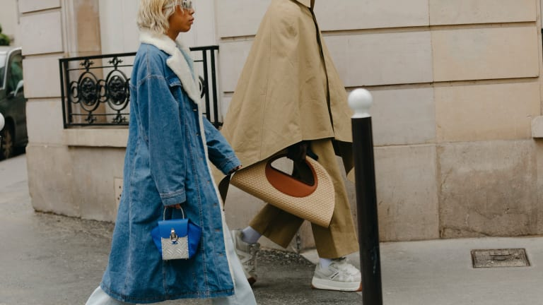 A fashion model holding a designer handbag at an event