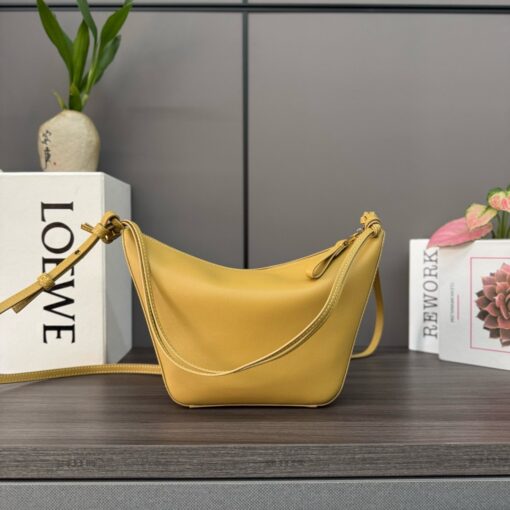 LOEWE Mini Hammock Hobo. Authentic quality luxury bag crafted in genuine leather comes with authenticity card, dust bag and gift bag. Effortless Form, Everyday Function. The Mini Hammock Hobo is a contemporary reimagining of Loewe’s iconic Hammock bag. This streamlined variation offers a sleek, sculptural silhouette designed as a versatile sling bag for modern living. Expertly crafted in classic calfskin, it features soft, supple leather and a compact form that adapts effortlessly to your day. The unique design allows for multiple carry options—wear it crossbody, over the shoulder, or by hand. Elegant yet functional, this mini hobo is perfect for essentials, making it an ideal choice for both daily wear and minimalist style statements.