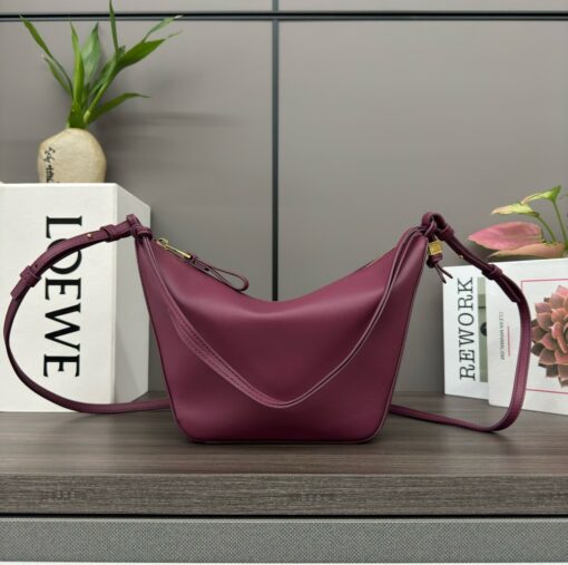 LOEWE Mini Hammock Hobo. Authentic quality luxury bag crafted in genuine leather comes with authenticity card, dust bag and gift bag. Effortless Form, Everyday Function. The Mini Hammock Hobo is a contemporary reimagining of Loewe’s iconic Hammock bag. This streamlined variation offers a sleek, sculptural silhouette designed as a versatile sling bag for modern living. Expertly crafted in classic calfskin, it features soft, supple leather and a compact form that adapts effortlessly to your day. The unique design allows for multiple carry options—wear it crossbody, over the shoulder, or by hand. Elegant yet functional, this mini hobo is perfect for essentials, making it an ideal choice for both daily wear and minimalist style statements.