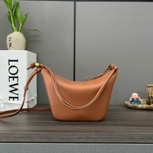 LOEWE Mini Hammock Hobo. Authentic quality luxury bag crafted in genuine leather comes with authenticity card, dust bag and gift bag. Effortless Form, Everyday Function. The Mini Hammock Hobo is a contemporary reimagining of Loewe’s iconic Hammock bag. This streamlined variation offers a sleek, sculptural silhouette designed as a versatile sling bag for modern living. Expertly crafted in classic calfskin, it features soft, supple leather and a compact form that adapts effortlessly to your day. The unique design allows for multiple carry options—wear it crossbody, over the shoulder, or by hand. Elegant yet functional, this mini hobo is perfect for essentials, making it an ideal choice for both daily wear and minimalist style statements.