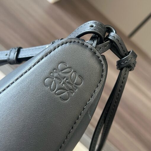 LOEWE Mini Hammock Hobo. Authentic quality luxury bag crafted in genuine leather comes with authenticity card, dust bag and gift bag. Effortless Form, Everyday Function. The Mini Hammock Hobo is a contemporary reimagining of Loewe’s iconic Hammock bag. This streamlined variation offers a sleek, sculptural silhouette designed as a versatile sling bag for modern living. Expertly crafted in classic calfskin, it features soft, supple leather and a compact form that adapts effortlessly to your day. The unique design allows for multiple carry options—wear it crossbody, over the shoulder, or by hand. Elegant yet functional, this mini hobo is perfect for essentials, making it an ideal choice for both daily wear and minimalist style statements.
