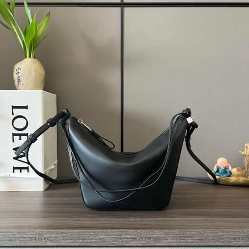 LOEWE Mini Hammock Hobo. Authentic quality luxury bag crafted in genuine leather comes with authenticity card, dust bag and gift bag. Effortless Form, Everyday Function. The Mini Hammock Hobo is a contemporary reimagining of Loewe’s iconic Hammock bag. This streamlined variation offers a sleek, sculptural silhouette designed as a versatile sling bag for modern living. Expertly crafted in classic calfskin, it features soft, supple leather and a compact form that adapts effortlessly to your day. The unique design allows for multiple carry options—wear it crossbody, over the shoulder, or by hand. Elegant yet functional, this mini hobo is perfect for essentials, making it an ideal choice for both daily wear and minimalist style statements.