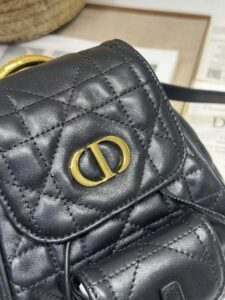 DIOR Small Caro Backpack. Authentic quality luxury bag crafted in genuine leather comes with authenticity card, dust bag and gift bag. Elegance Meets Effortless Edge. Elevate your everyday with the DIOR Small Caro Backpack — a flawless blend of modern femininity and iconic House craftsmanship. Luxuriously crafted in lambskin, its supple silhouette is enhanced by bold Macrocannage topstitching that whispers timeless Dior style. The antique gold-finish ‘CD’ clasp opens to a drawstring main compartment, perfectly balancing beauty and practicality. A discreet flap pocket keeps your daily essentials close at hand, while the top handle and adjustable leather straps offer versatile, all-day comfort. Whether slung over your shoulder or carried by hand, this petite powerhouse delivers Parisian polish in every step.