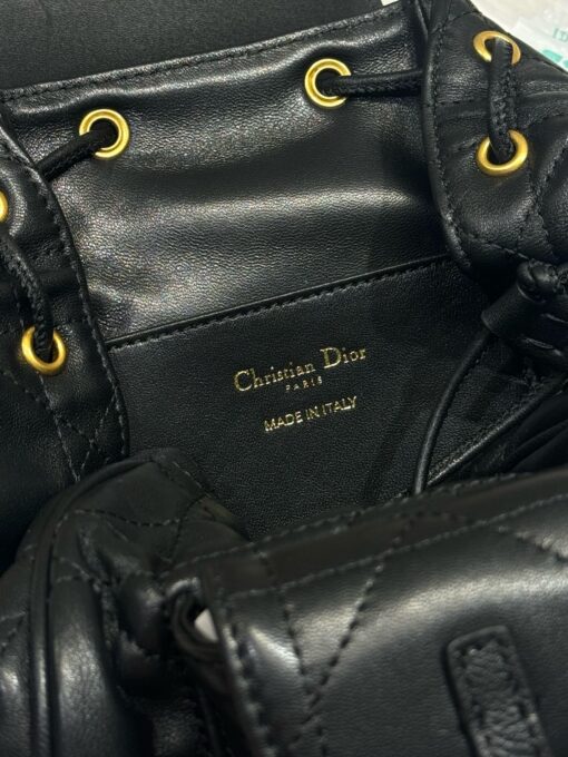 DIOR Small Caro Backpack. Authentic quality luxury bag crafted in genuine leather comes with authenticity card, dust bag and gift bag. Elegance Meets Effortless Edge. Elevate your everyday with the DIOR Small Caro Backpack — a flawless blend of modern femininity and iconic House craftsmanship. Luxuriously crafted in lambskin, its supple silhouette is enhanced by bold Macrocannage topstitching that whispers timeless Dior style. The antique gold-finish ‘CD’ clasp opens to a drawstring main compartment, perfectly balancing beauty and practicality. A discreet flap pocket keeps your daily essentials close at hand, while the top handle and adjustable leather straps offer versatile, all-day comfort. Whether slung over your shoulder or carried by hand, this petite powerhouse delivers Parisian polish in every step.