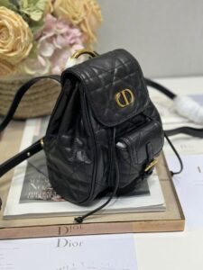DIOR Small Caro Backpack. Authentic quality luxury bag crafted in genuine leather comes with authenticity card, dust bag and gift bag. Elegance Meets Effortless Edge. Elevate your everyday with the DIOR Small Caro Backpack — a flawless blend of modern femininity and iconic House craftsmanship. Luxuriously crafted in lambskin, its supple silhouette is enhanced by bold Macrocannage topstitching that whispers timeless Dior style. The antique gold-finish ‘CD’ clasp opens to a drawstring main compartment, perfectly balancing beauty and practicality. A discreet flap pocket keeps your daily essentials close at hand, while the top handle and adjustable leather straps offer versatile, all-day comfort. Whether slung over your shoulder or carried by hand, this petite powerhouse delivers Parisian polish in every step.