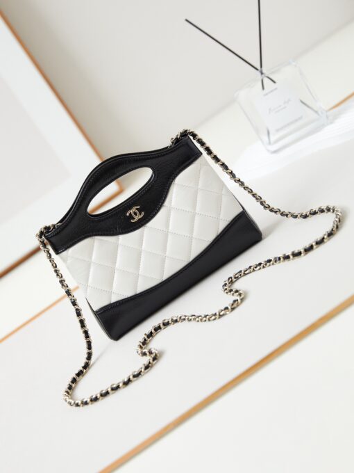 CHANEL 31 Nano Shopping Bag. Authentic quality luxury bag crafted in genuine leather comes with authenticity card, dust bag and gift bag. Small in size, grand in statement. A miniature marvel that captures the sophistication of CHANEL in its most playful form. Crafted with meticulous precision, this petite icon merges the timeless spirit of the CHANEL 31 with a modern twist on everyday elegance. Designed in supple lambskin and finished with gleaming gold-tone hardware, the Nano 31 doesn’t just carry your essentials — it carries your attitude. Whether worn crossbody, by hand, or dangling from the crook of your arm, this charming piece elevates every ensemble with a whisper of Parisian chic. Perfect for a night out or a day in the spotlight, it’s not just a bag — it’s your boldest accessory in its most compact form. Because luxury doesn't need to shout. Sometimes, it just needs to charm.