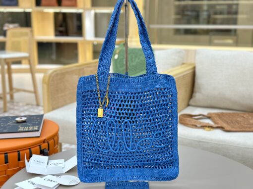 CHLOÉ Summer Banana Tote Bag. Authentic quality luxury bag crafted in genuine leather comes with authenticity card, dust bag and gift bag. Heritage in Hand: Where Artisan Craft Meets Summer Elegance. Introducing the Summer Banana Tote—an artisanal masterpiece crafted from raffia and calfskin by a single artisan over 4.5 days in partnership with Made For A Woman. This spacious tote is adorned with a handwritten signature inspired by Chloé’s rich heritage, while a playful dangling chain and delicate charms add the perfect finishing touch. A celebration of craftsmanship and effortless summer style.