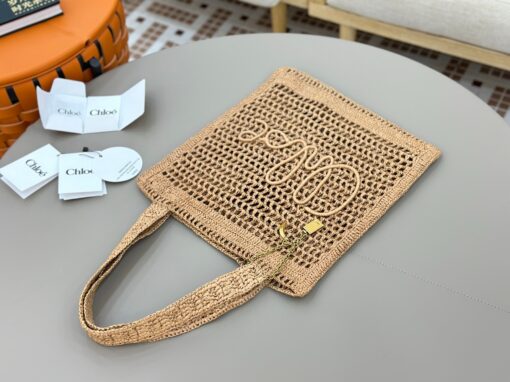 CHLOÉ Summer Banana Tote Bag. Authentic quality luxury bag crafted in genuine leather comes with authenticity card, dust bag and gift bag. Heritage in Hand: Where Artisan Craft Meets Summer Elegance. Introducing the Summer Banana Tote—an artisanal masterpiece crafted from raffia and calfskin by a single artisan over 4.5 days in partnership with Made For A Woman. This spacious tote is adorned with a handwritten signature inspired by Chloé’s rich heritage, while a playful dangling chain and delicate charms add the perfect finishing touch. A celebration of craftsmanship and effortless summer style.