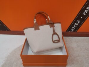 HERMÈS Steeple 25 Bag. Authentic quality luxury bag crafted in genuine leather comes with authenticity card, dust bag and gift bag. Where art meets heritage. The Hermès Steeple Bag is a charming fusion of heritage and artistry, crafted from a blend of canvas and Swift leather. Its design pays tribute to Hermès’ equestrian roots with whip-shaped handles and a stirrup-inspired charm, adding a playful yet sophisticated touch. Lightweight yet spacious, the Steeple is ideal for daily use. Whether you opt for a vibrant motif or a sleek, single-color design, this bag stands out as an artistic expression of luxury that seamlessly integrates into a modern lifestyle. Praised for its unique aesthetic and accessibility within the Hermès lineup, the Steeple Bag is adored by fashion enthusiasts who appreciate its colorful palette and bold personality. While it’s best suited for those who enjoy the texture and look of canvas, it remains a versatile statement piece that captures the spirit of everyday elegance. - KRIS + KIKO HERMÈS Steeple 25 Bag. Authentic quality luxury bag crafted in genuine leather comes with authenticity card, dust bag and gift bag. Where art meets heritage. The Hermès Steeple Bag is a charming fusion of heritage and artistry, crafted from a blend of canvas and Swift leather. Its design pays tribute to Hermès’ equestrian roots with whip-shaped handles and a stirrup-inspired charm, adding a playful yet sophisticated touch. Lightweight yet spacious, the Steeple is ideal for daily use. Whether you opt for a vibrant motif or a sleek, single-color design, this bag stands out as an artistic expression of luxury that seamlessly integrates into a modern lifestyle. Praised for its unique aesthetic and accessibility within the Hermès lineup, the Steeple Bag is adored by fashion enthusiasts who appreciate its colorful palette and bold personality. While it’s best suited for those who enjoy the texture and look of canvas, it remains a versatile statement piece that captures the spirit of everyday elegance.