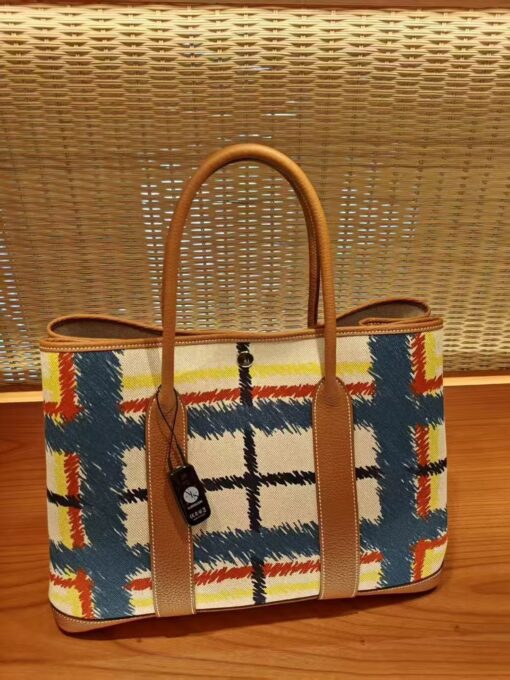 HERMÈS Garden Party Voyage. Authentic quality luxury bag crafted in genuine leather comes with authenticity card, dust bag and gift bag. The Art of Everyday Escape. Chic, structured, and effortlessly refined, the HERMÈS Garden Party Voyage is the perfect companion for your daily adventures or spontaneous weekend getaways. Crafted with precision in supple Negonda leather or canvas with leather trim, this midsize tote strikes the perfect balance between luxury and functionality. Its minimalist silhouette is elevated by discreet Clou de Selle snap closures and expandable sides, offering both form and flexibility. Spacious enough for your essentials yet compact enough to carry with ease, it’s a timeless piece designed to move with you—gracefully. Whether carried in hand or worn over the shoulder, the Garden Party Voyage 36 speaks in whispers of elegance and unmistakable HERMÈS craftsmanship. Every day is a journey. Travel beautifully.