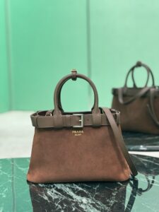 PRADA Buckle Small Leather Handbag. Authentic quality luxury bag crafted in genuine leather comes with authenticity card, dust bag and gift bag. Sophistication Meets Utility. Sleek, structured, and undeniably Prada — the Buckle Small Leather Handbag captures the brand’s signature balance of minimalist elegance and refined detail. Crafted in smooth leather with a buttery-soft nappa interior, this compact piece is a masterclass in functional luxury. A standout feature? Its interchangeable belt strap, adding a bold, modern twist to the timeless silhouette. Whether you're heading to a meeting or a soirée, this bag adapts seamlessly to your mood and moment. Finished with the embossed iconic PRADA logo, it’s a quiet statement of taste and distinction. A versatile companion for the woman who appreciates precision, polish, and just the right touch of edge. - KRIS + KIKO PRADA Buckle Small Leather Handbag. Authentic quality luxury bag crafted in genuine leather comes with authenticity card, dust bag and gift bag. Sophistication Meets Utility. Sleek, structured, and undeniably Prada — the Buckle Small Leather Handbag captures the brand’s signature balance of minimalist elegance and refined detail. Crafted in smooth leather with a buttery-soft nappa interior, this compact piece is a masterclass in functional luxury. A standout feature? Its interchangeable belt strap, adding a bold, modern twist to the timeless silhouette. Whether you're heading to a meeting or a soirée, this bag adapts seamlessly to your mood and moment. Finished with the embossed iconic PRADA logo, it’s a quiet statement of taste and distinction. A versatile companion for the woman who appreciates precision, polish, and just the right touch of edge.