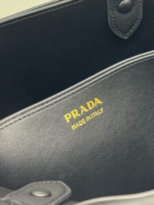 PRADA Buckle Small Leather Handbag. Authentic quality luxury bag crafted in genuine leather comes with authenticity card, dust bag and gift bag. Sophistication Meets Utility. Sleek, structured, and undeniably Prada — the Buckle Small Leather Handbag captures the brand’s signature balance of minimalist elegance and refined detail. Crafted in smooth leather with a buttery-soft nappa interior, this compact piece is a masterclass in functional luxury. A standout feature? Its interchangeable belt strap, adding a bold, modern twist to the timeless silhouette. Whether you're heading to a meeting or a soirée, this bag adapts seamlessly to your mood and moment. Finished with the embossed iconic PRADA logo, it’s a quiet statement of taste and distinction. A versatile companion for the woman who appreciates precision, polish, and just the right touch of edge. - KRIS + KIKO PRADA Buckle Small Leather Handbag. Authentic quality luxury bag crafted in genuine leather comes with authenticity card, dust bag and gift bag. Sophistication Meets Utility. Sleek, structured, and undeniably Prada — the Buckle Small Leather Handbag captures the brand’s signature balance of minimalist elegance and refined detail. Crafted in smooth leather with a buttery-soft nappa interior, this compact piece is a masterclass in functional luxury. A standout feature? Its interchangeable belt strap, adding a bold, modern twist to the timeless silhouette. Whether you're heading to a meeting or a soirée, this bag adapts seamlessly to your mood and moment. Finished with the embossed iconic PRADA logo, it’s a quiet statement of taste and distinction. A versatile companion for the woman who appreciates precision, polish, and just the right touch of edge.