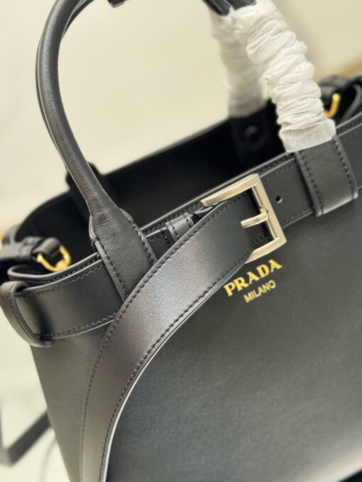 PRADA Buckle Small Leather Handbag. Authentic quality luxury bag crafted in genuine leather comes with authenticity card, dust bag and gift bag. Sophistication Meets Utility. Sleek, structured, and undeniably Prada — the Buckle Small Leather Handbag captures the brand’s signature balance of minimalist elegance and refined detail. Crafted in smooth leather with a buttery-soft nappa interior, this compact piece is a masterclass in functional luxury. A standout feature? Its interchangeable belt strap, adding a bold, modern twist to the timeless silhouette. Whether you're heading to a meeting or a soirée, this bag adapts seamlessly to your mood and moment. Finished with the embossed iconic PRADA logo, it’s a quiet statement of taste and distinction. A versatile companion for the woman who appreciates precision, polish, and just the right touch of edge.