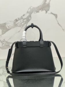 PRADA Buckle Small Leather Handbag. Authentic quality luxury bag crafted in genuine leather comes with authenticity card, dust bag and gift bag. Sophistication Meets Utility. Sleek, structured, and undeniably Prada — the Buckle Small Leather Handbag captures the brand’s signature balance of minimalist elegance and refined detail. Crafted in smooth leather with a buttery-soft nappa interior, this compact piece is a masterclass in functional luxury. A standout feature? Its interchangeable belt strap, adding a bold, modern twist to the timeless silhouette. Whether you're heading to a meeting or a soirée, this bag adapts seamlessly to your mood and moment. Finished with the embossed iconic PRADA logo, it’s a quiet statement of taste and distinction. A versatile companion for the woman who appreciates precision, polish, and just the right touch of edge. - KRIS + KIKO PRADA Buckle Small Leather Handbag. Authentic quality luxury bag crafted in genuine leather comes with authenticity card, dust bag and gift bag. Sophistication Meets Utility. Sleek, structured, and undeniably Prada — the Buckle Small Leather Handbag captures the brand’s signature balance of minimalist elegance and refined detail. Crafted in smooth leather with a buttery-soft nappa interior, this compact piece is a masterclass in functional luxury. A standout feature? Its interchangeable belt strap, adding a bold, modern twist to the timeless silhouette. Whether you're heading to a meeting or a soirée, this bag adapts seamlessly to your mood and moment. Finished with the embossed iconic PRADA logo, it’s a quiet statement of taste and distinction. A versatile companion for the woman who appreciates precision, polish, and just the right touch of edge.