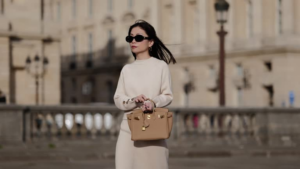 Woman in oversized sunglasses walking in SoHo with pastel Hermès-style bag