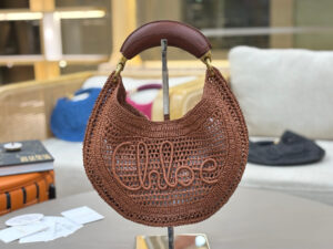 CHLOÉ Summer Banana Hobo. Authentic quality luxury bag crafted in genuine leather comes with authenticity card, dust bag and gift bag. Artisanal Spirit, Curved in Style. Say hello to sunshine in bag form. The CHLOÉ Summer Banana Hobo Bag is a joyful blend of craftsmanship and creativity, handwoven over four days by a single artisan in collaboration with Made For A Woman. This is not just a bag—it’s a story stitched in raffia and trimmed in luxurious calfskin. Its curved, banana-inspired silhouette hugs the shoulder with ease, while the sculptural handle and handwritten signature nod to Chloé’s heritage of effortless elegance. Light, natural, and undeniably chic, it's the perfect companion for sun-soaked escapes or city strolls with a coastal state of mind. A celebration of craftsmanship, femininity, and the art of slow fashion. - KRIS + KIKO CHLOÉ Summer Banana Hobo. Authentic quality luxury bag crafted in genuine leather comes with authenticity card, dust bag and gift bag. Artisanal Spirit, Curved in Style. Say hello to sunshine in bag form. The CHLOÉ Summer Banana Hobo Bag is a joyful blend of craftsmanship and creativity, handwoven over four days by a single artisan in collaboration with Made For A Woman. This is not just a bag—it’s a story stitched in raffia and trimmed in luxurious calfskin. Its curved, banana-inspired silhouette hugs the shoulder with ease, while the sculptural handle and handwritten signature nod to Chloé’s heritage of effortless elegance. Light, natural, and undeniably chic, it's the perfect companion for sun-soaked escapes or city strolls with a coastal state of mind. A celebration of craftsmanship, femininity, and the art of slow fashion.