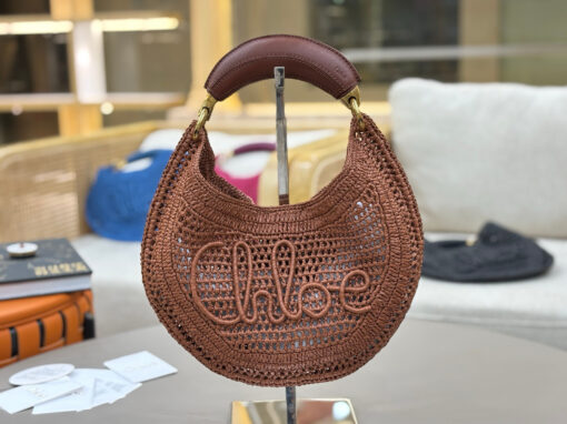 CHLOÉ Summer Banana Hobo. Authentic quality luxury bag crafted in genuine leather comes with authenticity card, dust bag and gift bag. Artisanal Spirit, Curved in Style. Say hello to sunshine in bag form. The CHLOÉ Summer Banana Hobo Bag is a joyful blend of craftsmanship and creativity, handwoven over four days by a single artisan in collaboration with Made For A Woman. This is not just a bag—it’s a story stitched in raffia and trimmed in luxurious calfskin. Its curved, banana-inspired silhouette hugs the shoulder with ease, while the sculptural handle and handwritten signature nod to Chloé’s heritage of effortless elegance. Light, natural, and undeniably chic, it's the perfect companion for sun-soaked escapes or city strolls with a coastal state of mind. A celebration of craftsmanship, femininity, and the art of slow fashion.