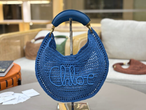 CHLOÉ Summer Banana Hobo. Authentic quality luxury bag crafted in genuine leather comes with authenticity card, dust bag and gift bag. Artisanal Spirit, Curved in Style. Say hello to sunshine in bag form. The CHLOÉ Summer Banana Hobo Bag is a joyful blend of craftsmanship and creativity, handwoven over four days by a single artisan in collaboration with Made For A Woman. This is not just a bag—it’s a story stitched in raffia and trimmed in luxurious calfskin. Its curved, banana-inspired silhouette hugs the shoulder with ease, while the sculptural handle and handwritten signature nod to Chloé’s heritage of effortless elegance. Light, natural, and undeniably chic, it's the perfect companion for sun-soaked escapes or city strolls with a coastal state of mind. A celebration of craftsmanship, femininity, and the art of slow fashion.