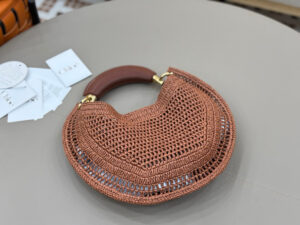 CHLOÉ Summer Banana Hobo. Authentic quality luxury bag crafted in genuine leather comes with authenticity card, dust bag and gift bag. Artisanal Spirit, Curved in Style. Say hello to sunshine in bag form. The CHLOÉ Summer Banana Hobo Bag is a joyful blend of craftsmanship and creativity, handwoven over four days by a single artisan in collaboration with Made For A Woman. This is not just a bag—it’s a story stitched in raffia and trimmed in luxurious calfskin. Its curved, banana-inspired silhouette hugs the shoulder with ease, while the sculptural handle and handwritten signature nod to Chloé’s heritage of effortless elegance. Light, natural, and undeniably chic, it's the perfect companion for sun-soaked escapes or city strolls with a coastal state of mind. A celebration of craftsmanship, femininity, and the art of slow fashion.