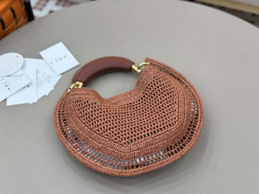 CHLOÉ Summer Banana Hobo. Authentic quality luxury bag crafted in genuine leather comes with authenticity card, dust bag and gift bag. Artisanal Spirit, Curved in Style. Say hello to sunshine in bag form. The CHLOÉ Summer Banana Hobo Bag is a joyful blend of craftsmanship and creativity, handwoven over four days by a single artisan in collaboration with Made For A Woman. This is not just a bag—it’s a story stitched in raffia and trimmed in luxurious calfskin. Its curved, banana-inspired silhouette hugs the shoulder with ease, while the sculptural handle and handwritten signature nod to Chloé’s heritage of effortless elegance. Light, natural, and undeniably chic, it's the perfect companion for sun-soaked escapes or city strolls with a coastal state of mind. A celebration of craftsmanship, femininity, and the art of slow fashion.