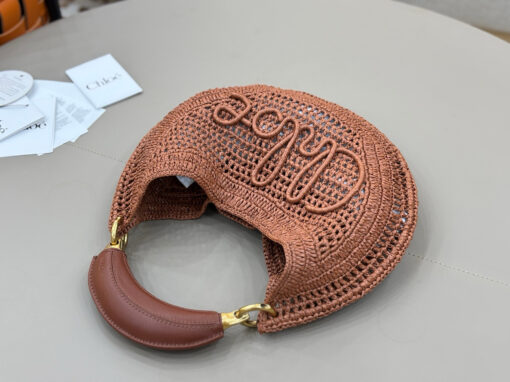CHLOÉ Summer Banana Hobo. Authentic quality luxury bag crafted in genuine leather comes with authenticity card, dust bag and gift bag. Artisanal Spirit, Curved in Style. Say hello to sunshine in bag form. The CHLOÉ Summer Banana Hobo Bag is a joyful blend of craftsmanship and creativity, handwoven over four days by a single artisan in collaboration with Made For A Woman. This is not just a bag—it’s a story stitched in raffia and trimmed in luxurious calfskin. Its curved, banana-inspired silhouette hugs the shoulder with ease, while the sculptural handle and handwritten signature nod to Chloé’s heritage of effortless elegance. Light, natural, and undeniably chic, it's the perfect companion for sun-soaked escapes or city strolls with a coastal state of mind. A celebration of craftsmanship, femininity, and the art of slow fashion.